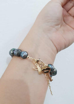 Pulseira Pérola De Água Doce. DESCRIÇÃO DO PRODUTO:Marca: FEITO A MÃO BIJUTERIAS FINASMateriais: pérola de água doce tingida na coloração grafite, pingente no formato de chave e anjinho... 